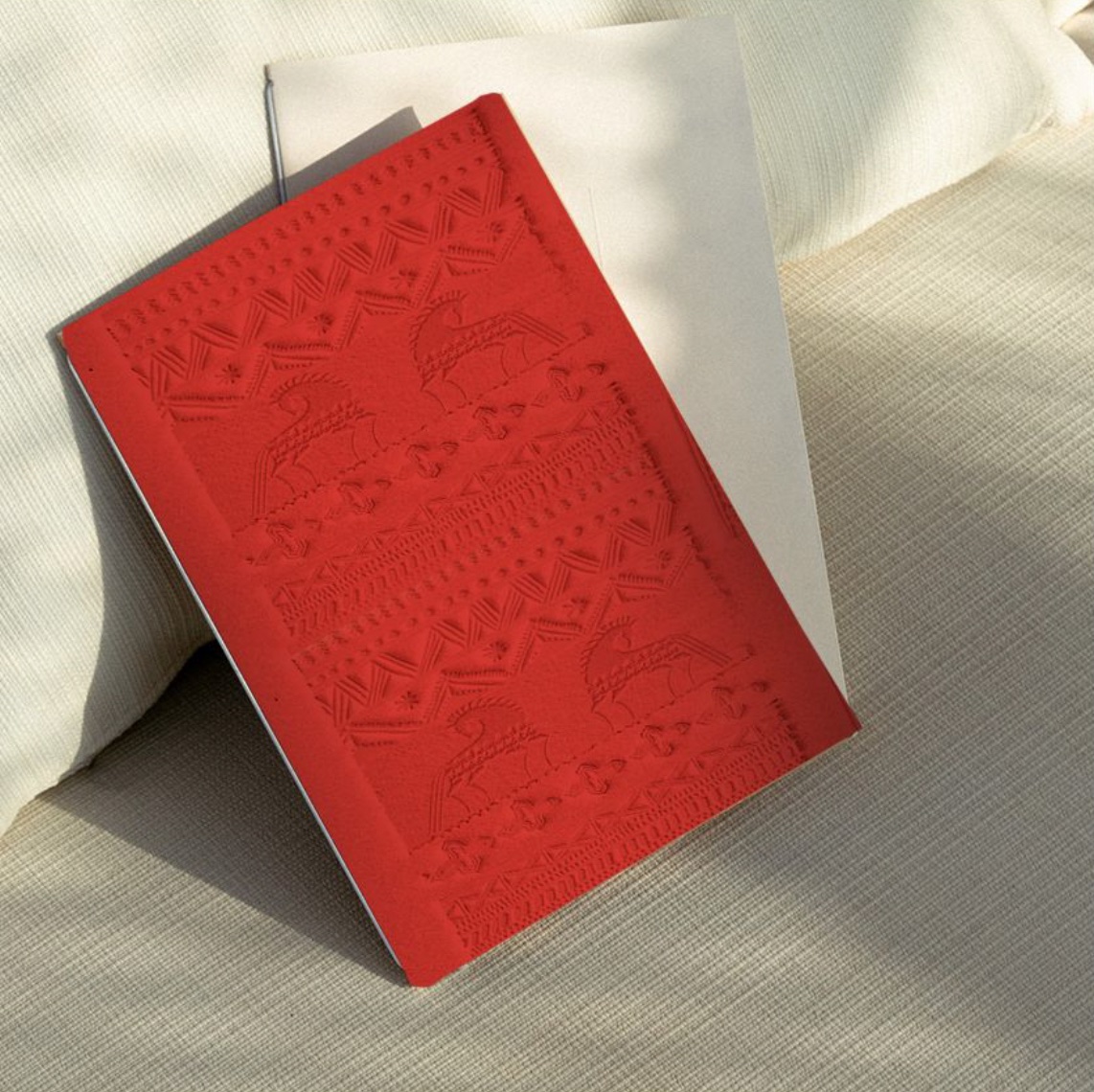 Red embossed brand menu on a warm neutral textile surface