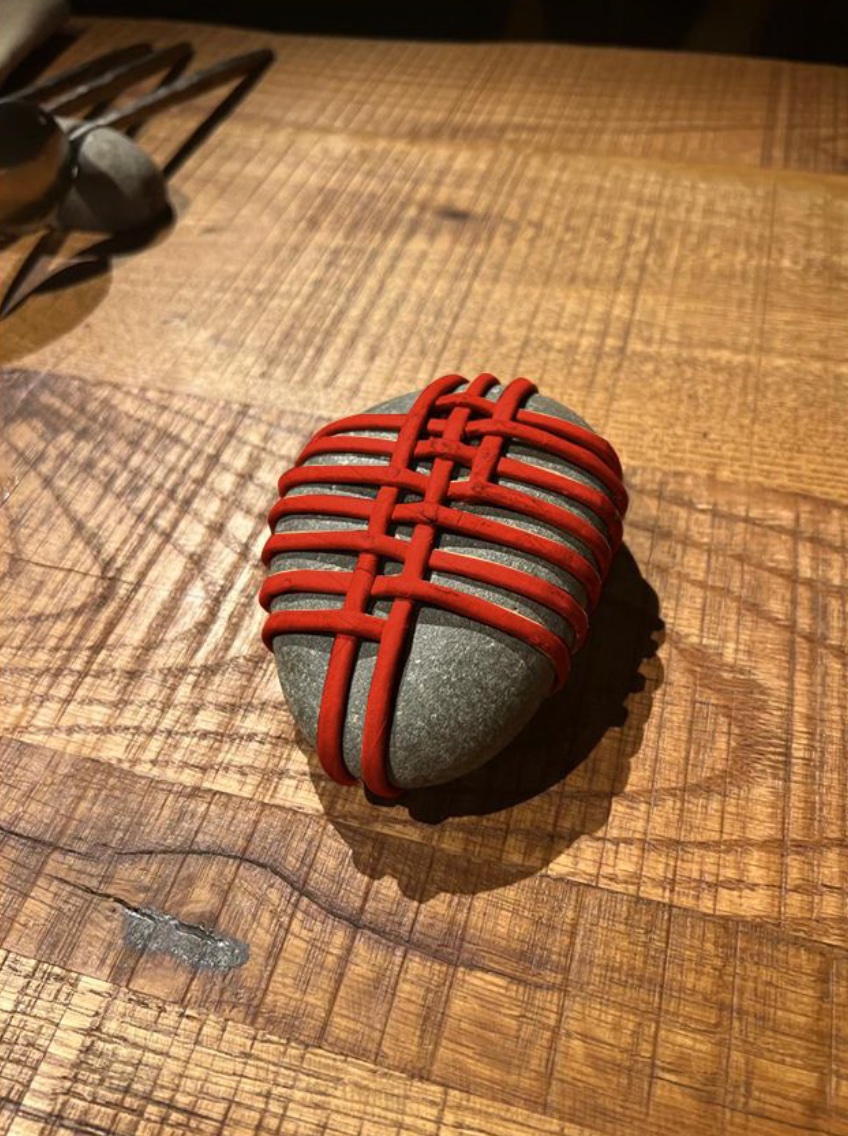 Red woven brand detail applied to a stone object