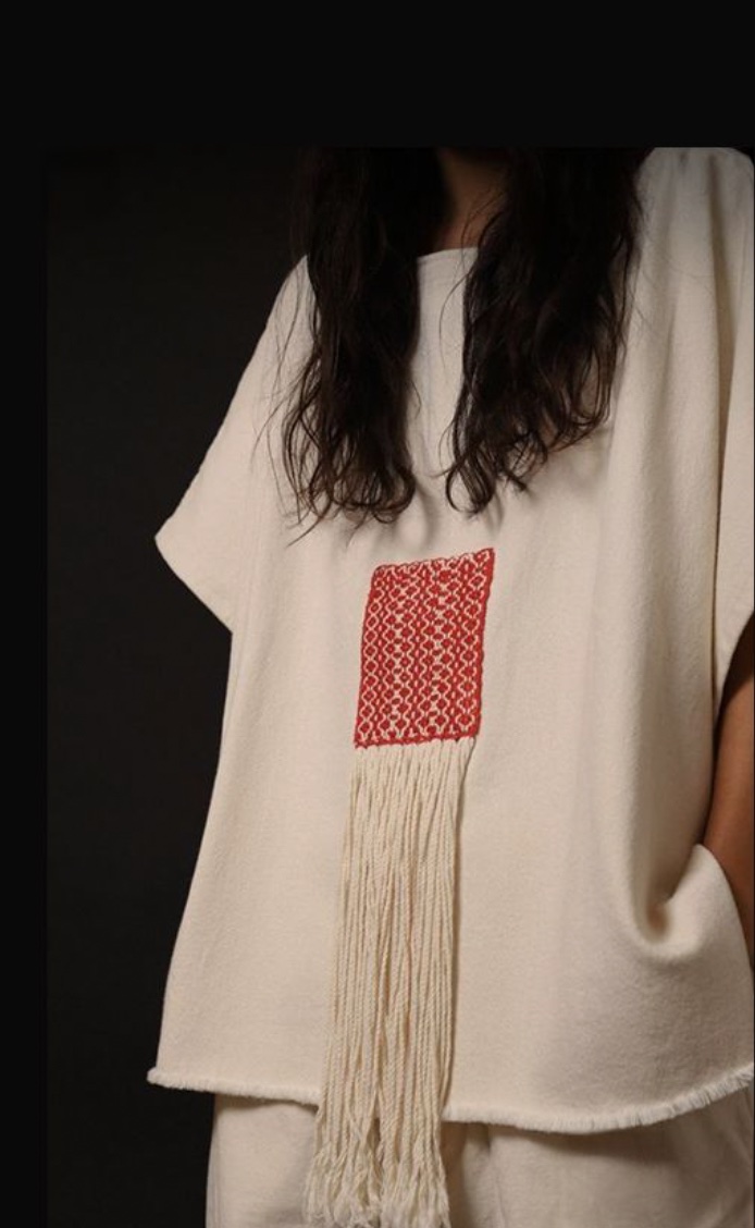 Cream uniform with a red woven brand application