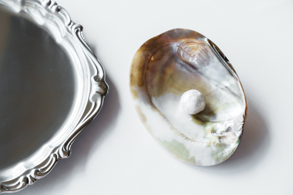 Pearl shell and silver service tray on a white restaurant table