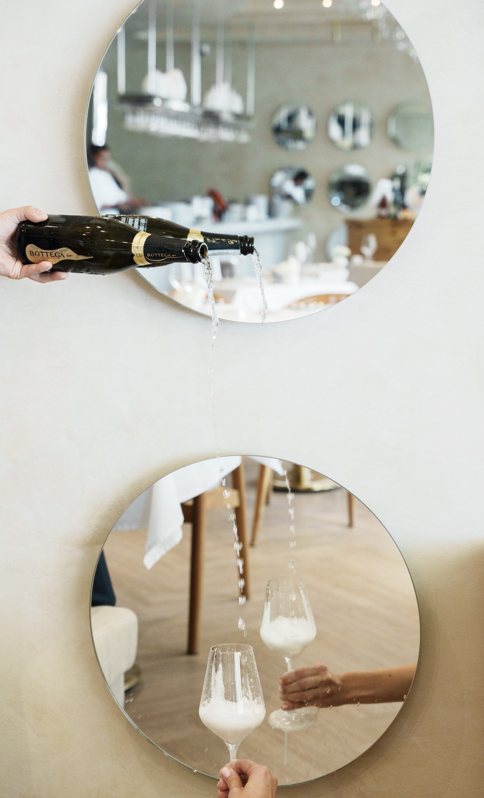 Sparkling wine being poured through restaurant mirrors for social media performance reporting in Thailand